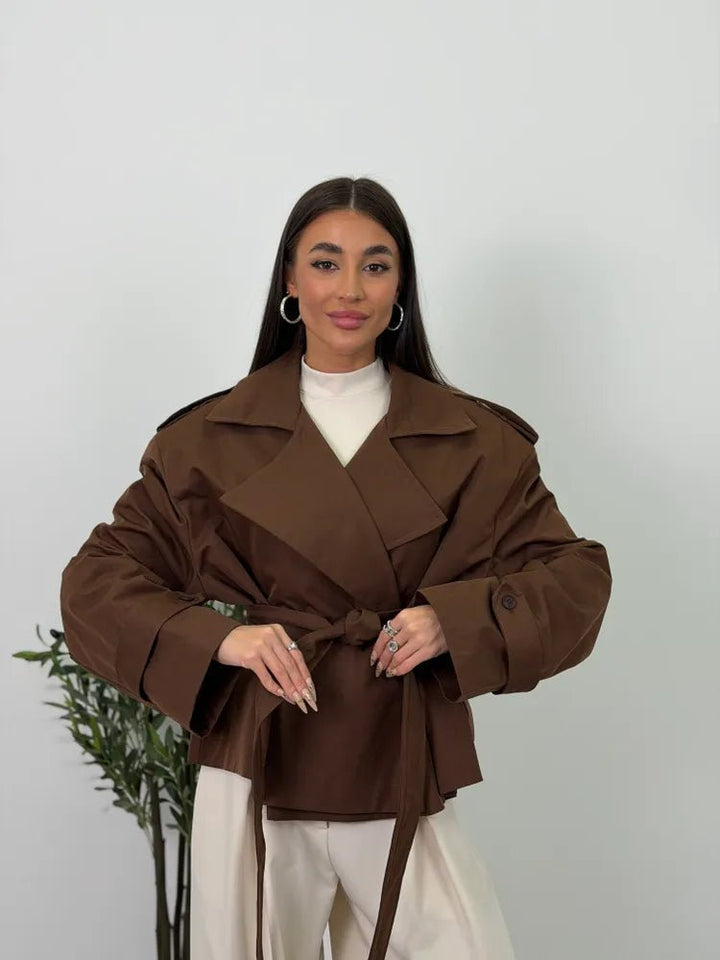 Women's brown cropped trench coat with wide lapels and tie belt