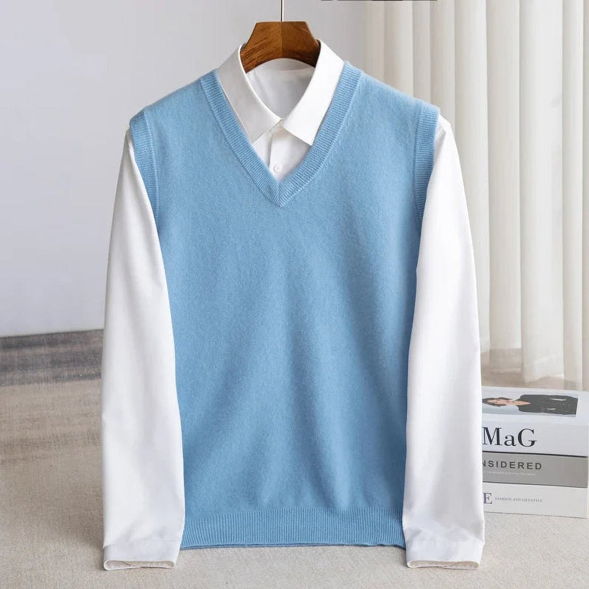 Women's sleeveless V-neck knit sweater vest layered over a white collared shirt