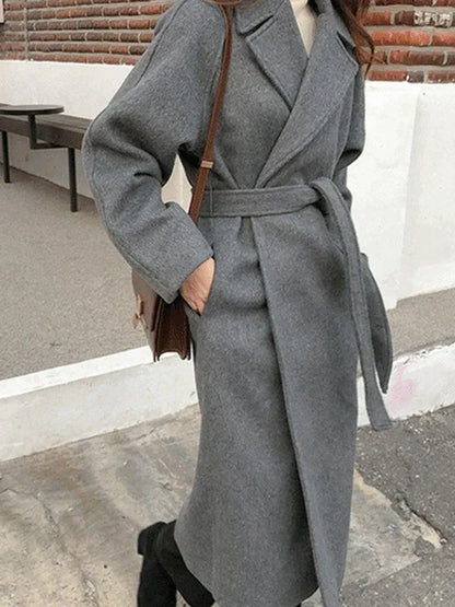 Women's long solid wrap coat with wide lapels and tie belt