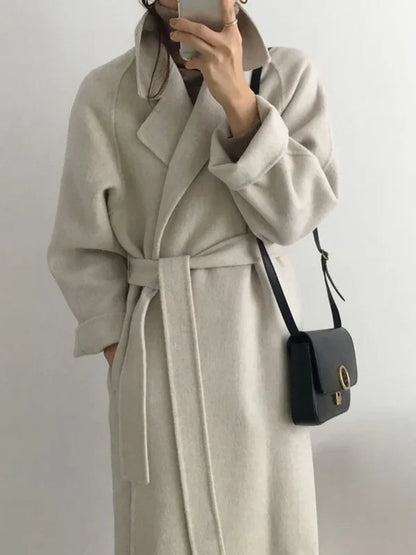 Women's long solid wrap coat with wide lapels and tie belt