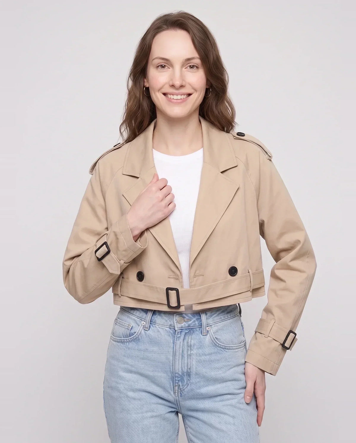 Women's beige cropped trench jacket with buckled belt and long sleeves