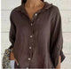 Woman wearing a relaxed button-up shirt with a point collar, dropped shoulders and rolled long sleeves