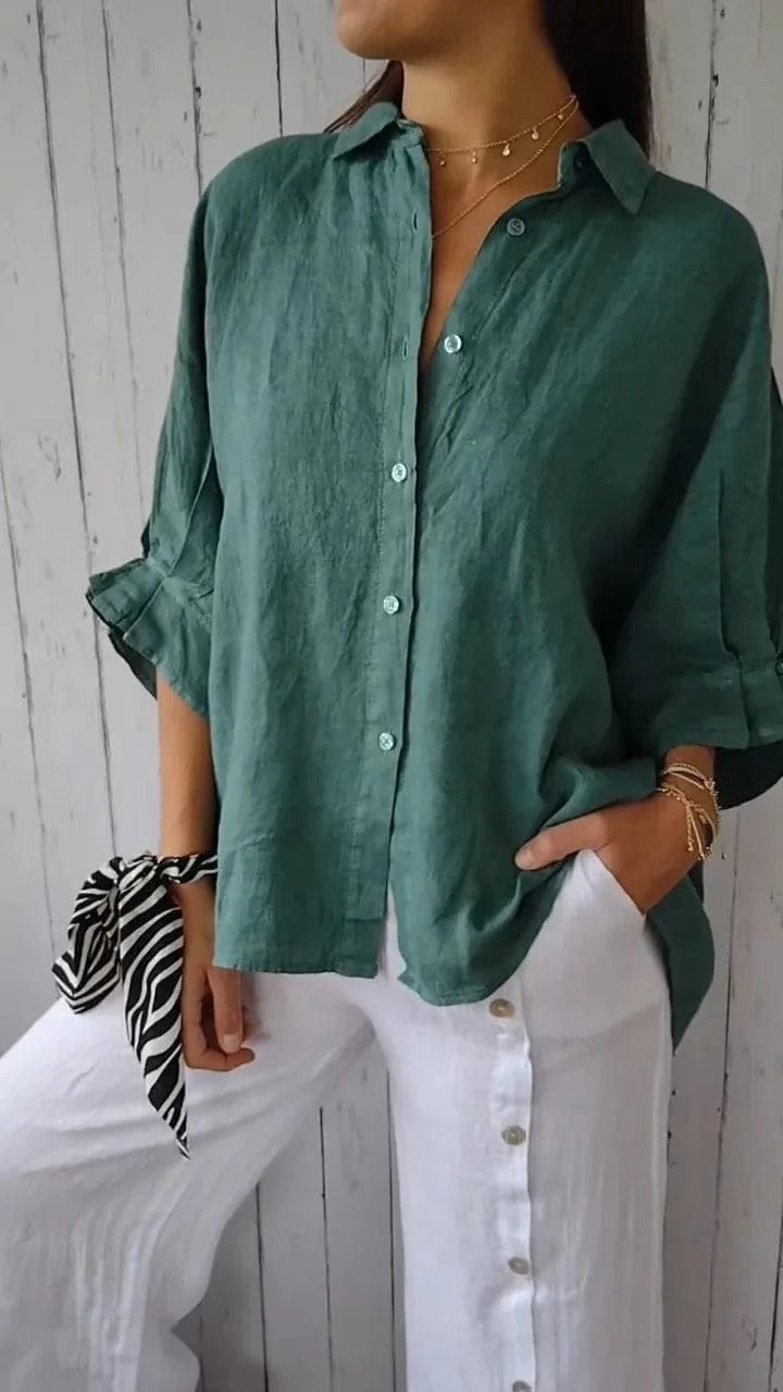 Woman wearing a relaxed button-up shirt with a point collar, dropped shoulders and rolled long sleeves
