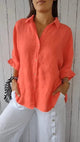 Woman wearing a relaxed button-up shirt with a point collar, dropped shoulders and rolled long sleeves