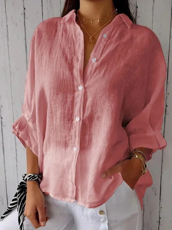 Woman wearing a relaxed button-up shirt with a point collar, dropped shoulders and rolled long sleeves
