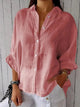 Woman wearing a relaxed button-up shirt with a point collar, dropped shoulders and rolled long sleeves