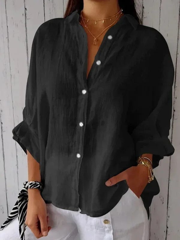 Woman wearing a relaxed button-up shirt with a point collar, dropped shoulders and rolled long sleeves