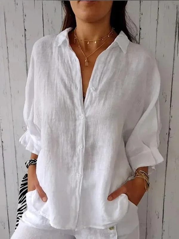 Woman wearing a relaxed button-up shirt with a point collar, dropped shoulders and rolled long sleeves