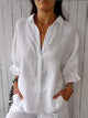 Woman wearing a relaxed button-up shirt with a point collar, dropped shoulders and rolled long sleeves
