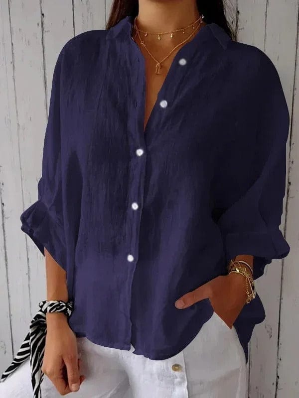 Woman wearing a relaxed button-up shirt with a point collar, dropped shoulders and rolled long sleeves