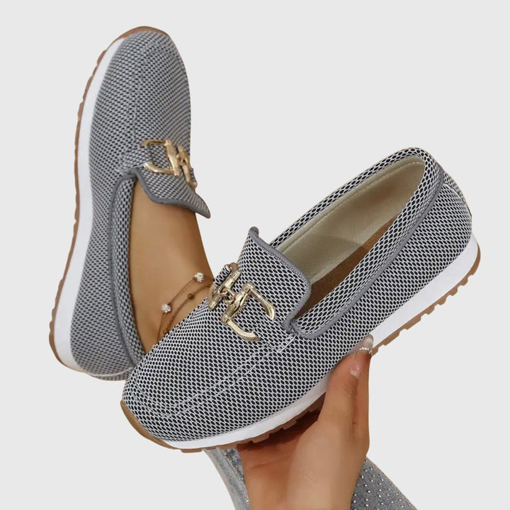 Women's textured slip-on loafers with decorative buckle detail and ridged soles