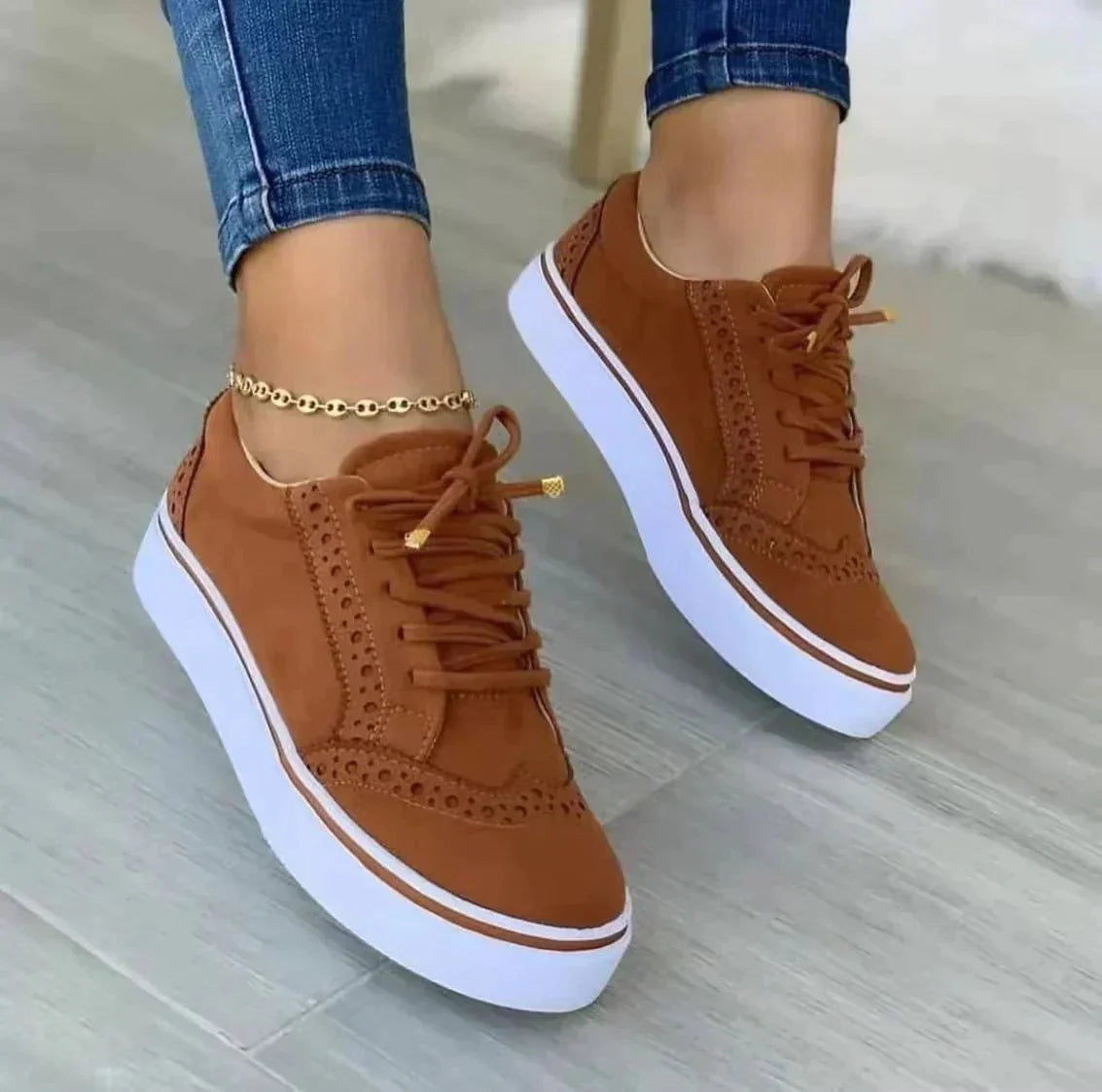 Women's low-top lace-up sneakers with brogue-style perforated detailing and thick platform soles